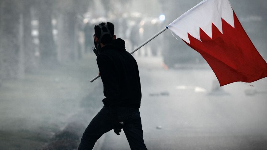 A Bahraini protester holds his national flag during clashes with riot police following the funeral of 20-year-old prisoner Fadel Abbas Musalem in the village of Diraz, west of the capital Manama, on January 26, 2014. The Gulf kingdom's main Shiite political opposition group said Musalem died the previous day as a result of torture during his detention. AFP PHOTO/MOHAMMED AL-SHAIKH (Photo by MOHAMMED AL-SHAIKH / AFP) (Photo by MOHAMMED AL-SHAIKH/AFP via Getty Images)